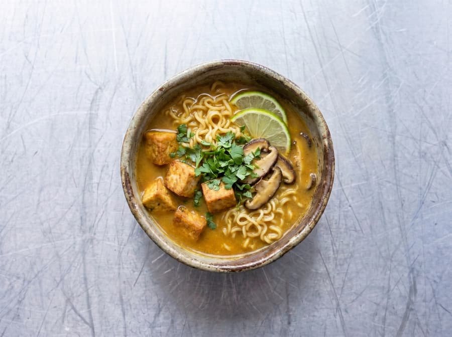 Coconut Curry Ramen with noodles in a rich broth, topped with vegetables
